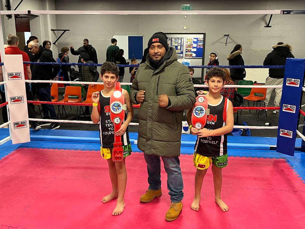 Ibrahim and Yousef, Afso Midlands Open K-1 Champion, celebrating victory with head coach.