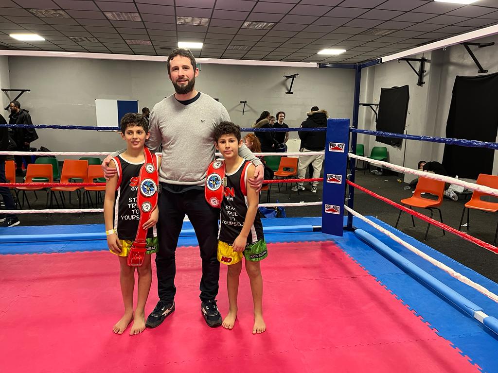 Ibrahim and Yousef, Afso Midlands Open K-1 Champion, celebrating victory with raised arms.