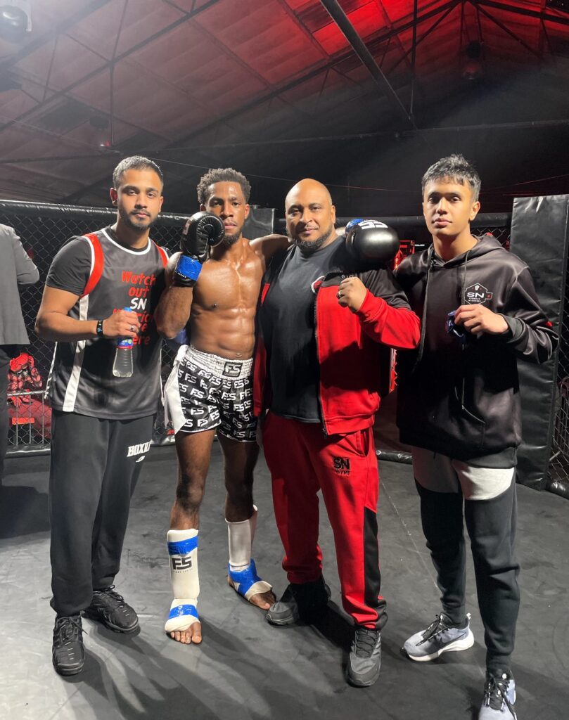 Nathan Lewis with his SN Combat Academy headcoach Khru Sam and his team pf fighters